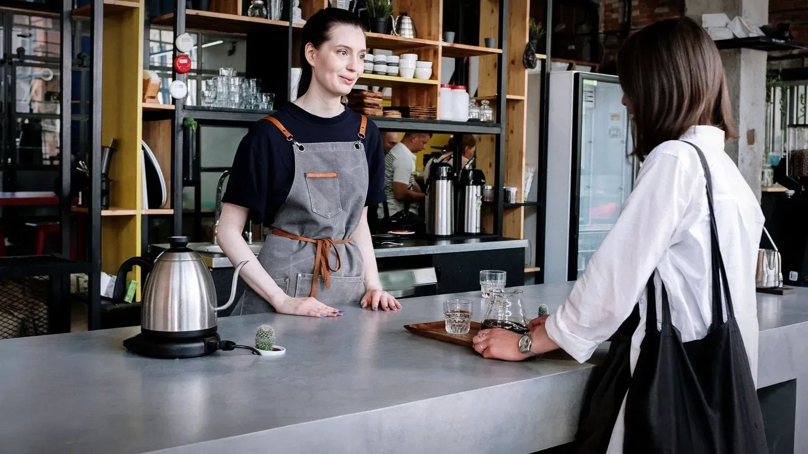 Customer talking with a barista across a concrete café counter