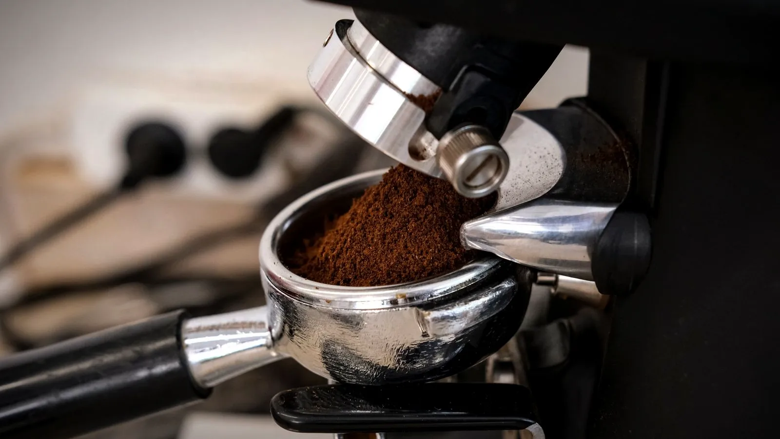 Freshly ground coffee falling from a grinder into an espresso portafilter