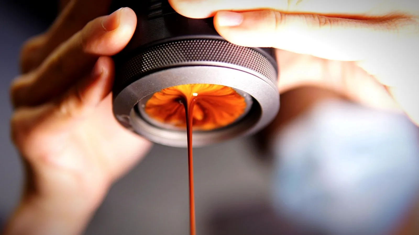 Espresso flowing from a handheld portable espresso maker