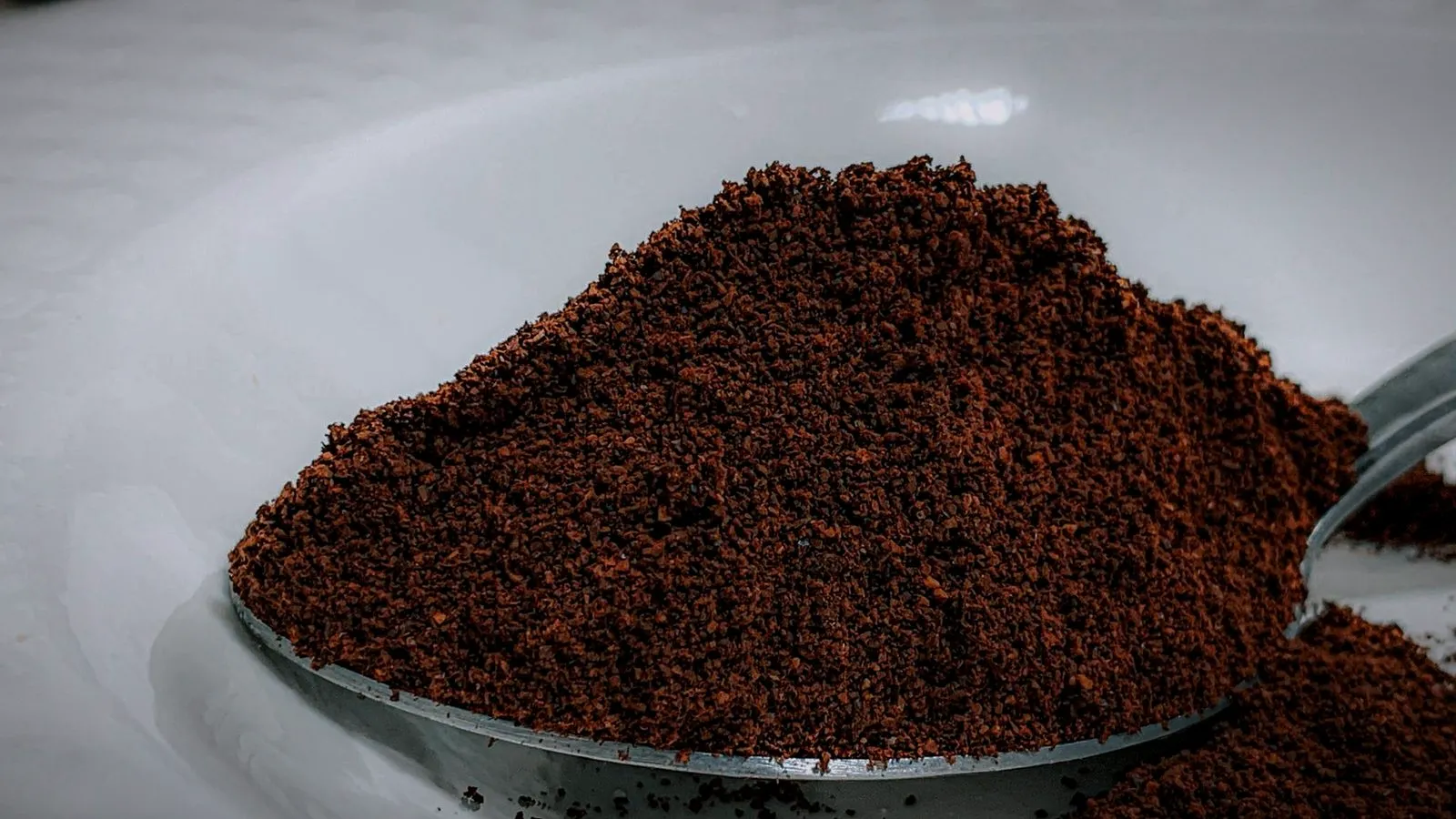 Spoon heaped with finely ground coffee, close up